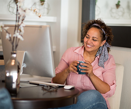 Woman Drinking Coffee Seeing Something on Her Computer