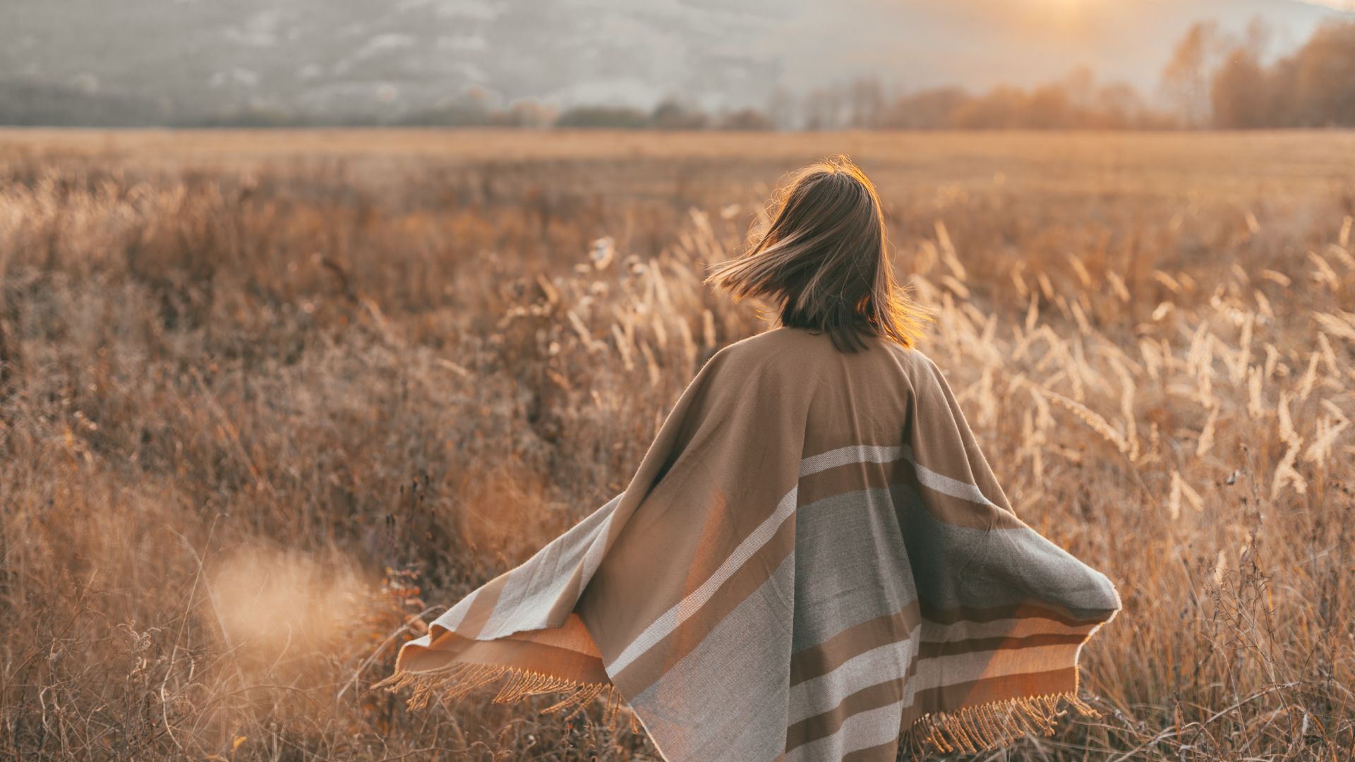 Girl In Poncho Alone In Field During Sunset